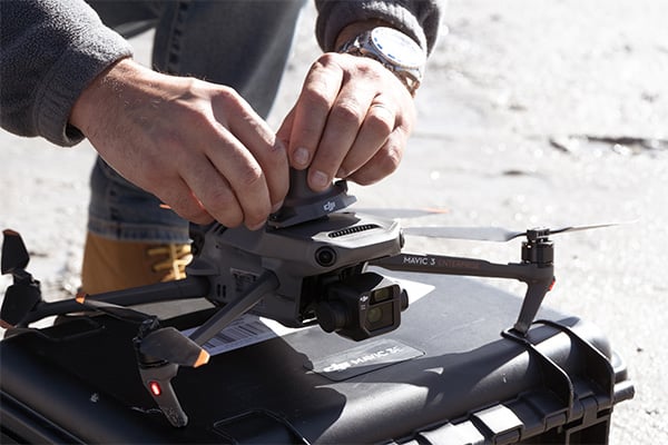 Mężczyzna montujący głośnik na dronie Dron DJI Mavic 3 Thermal Advanced C1