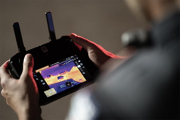 Osoba oglądająca nagranie na żywo z drona Dron DJI Mavic 3 Thermal Advanced C1, korzystając z termowizji