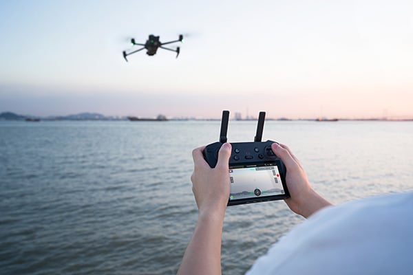 Osoba sterująca dronem Dron DJI Mavic 3 Thermal Advanced C1 za pomocą kontrolera