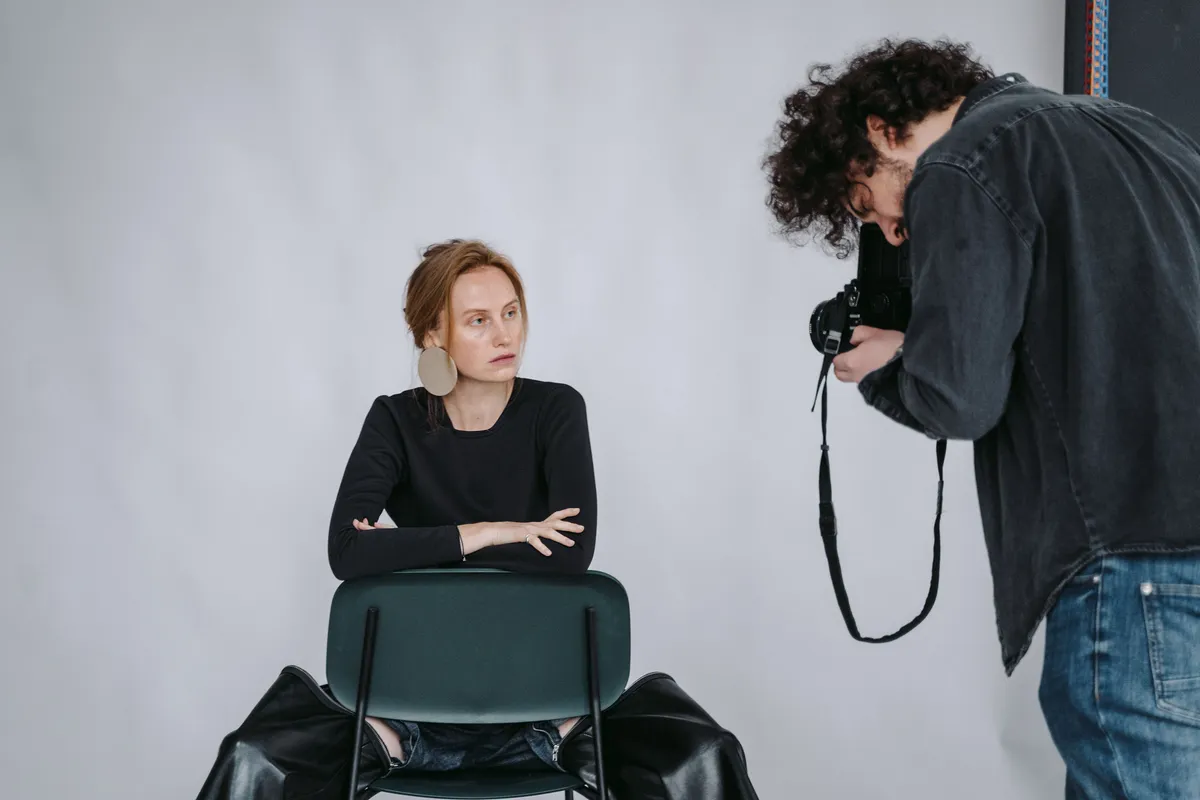 Fotograf portretowy robiący zdjęcie modelce na krześle